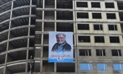 An electoral poster of current Afghan chief executive and presidential candidate Abdullah Abdullah is seen on a building under construction during the first day of campaigning in Kabul, Afghanistan, July 28, 2019.