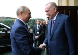 Turkish President Recep Tayyip Erdogan, right, welcomes Russian President Vladimir Putin, in Istanbul, Jan. 8, 2020.