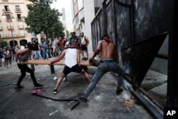 People try to break police barrier during a protest following last week's explosion that killed many and devastated the city, in Beirut, Lebanon, August 11, 2020.