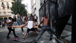 People try to break police barrier during a protest following last week's explosion that killed many and devastated the city, in Beirut, Lebanon, Aug. 11, 2020.