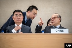 Chen Xu, head of the Chinese mission to the United Nations in Geneva, right, gestures prior to the review of China's rights record by the U.N. Human Rights Council in Geneva on Jan. 23, 2024.