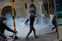 Manifestantes escapan de los gases lacrimógenos durante una protesta nacional contra la reforma fiscal propuesta por el presidente Duque en Bogotá, Colombia, el 28 de abril de 2021. [Foto: VOA/Pu Ying Huang]