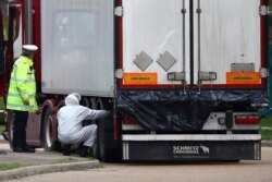 FILE - Police work at the scene where bodies were discovered in a lorry container, in Grays, Essex, Britain, Oct. 23, 2019.