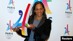 French track and field sprinter Christine Arron holds the logo as she attends the presentation of the Paris candidacy for the 2024 Olympic and Paralympic Games in Paris, Feb. 17, 2016.