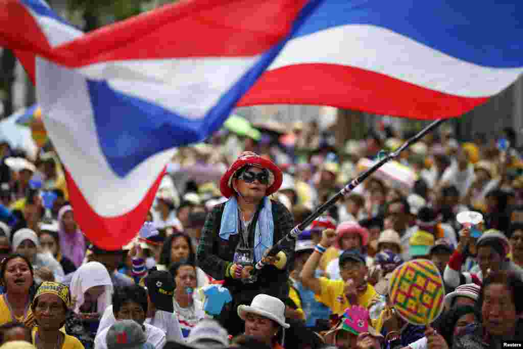 An anti-government protester waves a flag during a rally outside a compound of the country&#39;s parliament where members of the Senate are gathered for a meeting, in Bangkok, Thailand.