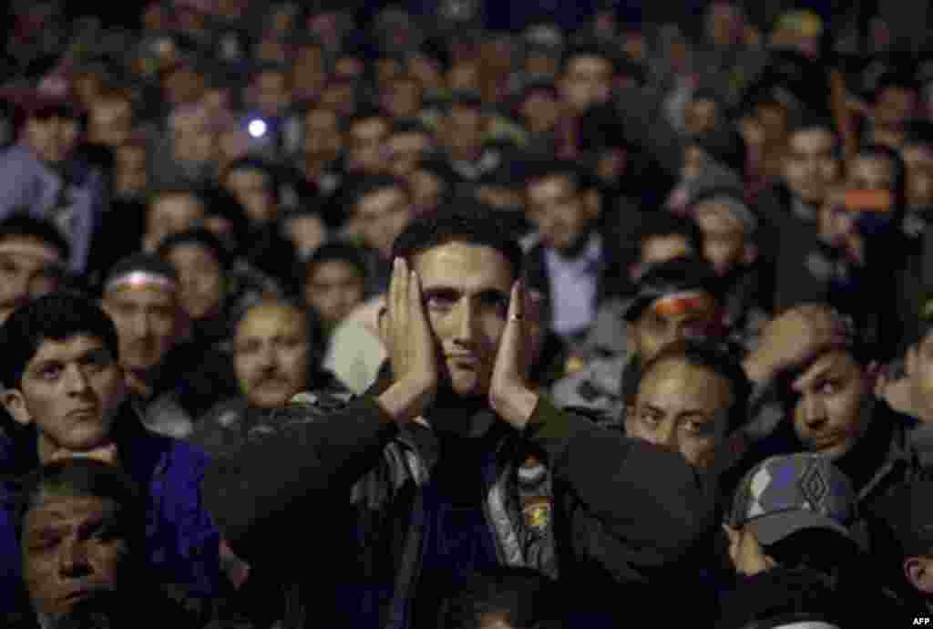 Anti-government protesters watch on big screen as Egyptian President Hosni Mubarak makes a televised statement to his nation in Tahrir Square in downtown Cairo, Egypt Thursday, Feb. 10, 2011. Egyptian President Hosni Mubarak announced he is handing his po