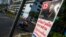 FILE - A motorcyclist rides past an election campaign poster of the ruling Pheu Thai Party, featuring a portrait of Prime Minister Yingluck Shinawatra, in central Bangkok, Jan. 3, 2014.