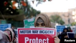 FILE - A supporter of religious and political party Jamaat-e-Islami carries a sign decrying a gang rape that occurred along a highway and condemning violence against women and girls, during a demonstration in Karachi, Pakistan, Sept. 11, 2020.