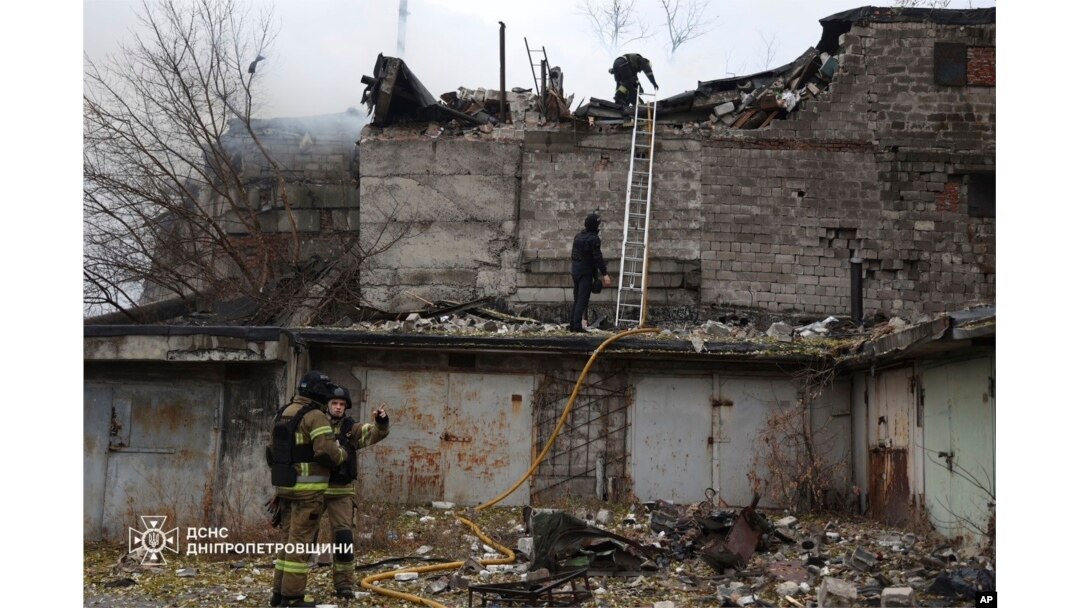 Petugas penyelamat memadamkan kebakaran di sebuah gedung yang rusak parah akibat serangan Rusia di Dnipro, Ukraina (Foto: via AP)