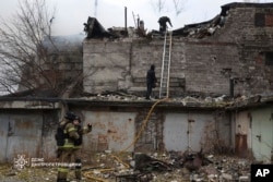 Petugas penyelamat memadamkan kebakaran di sebuah gedung yang rusak parah akibat serangan Rusia di Dnipro, Ukraina (Foto: via AP)