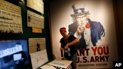 Kristin Guillot works on installing images of newspapers as part of the permanent exhibit "Salute to the Home Front" at the National World War II Museum which will open to the public in New Orleans, June 10, 2017. 