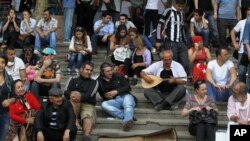 Para demonstran meneruskan aksi protes dengan duduk di tangga taman Gezi di Lapangan Taksim, Istanbul, Turki (15/6). 