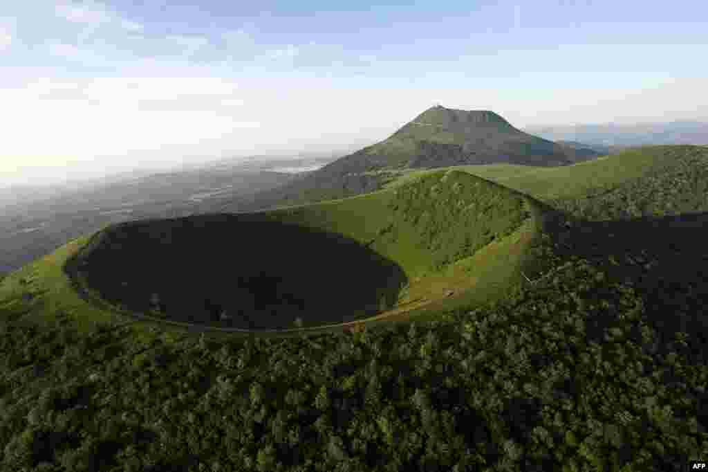 Sebuah foto menunjukkan Chaine des Puys, rangkaian dari&nbsp; 80 gunung berapi yang berada dalam jarak 32 km, dengan Puy de Dome (atas) dan Puy de Pariou (bawah) di dekat Clermont-Ferrand. Komite warisan dunia akan memutuskan pada tanggal 21 Juni 2014 apakah Chaine des Puys akan masuk dalam daftar Situs Warisan Dunia UNESCO.