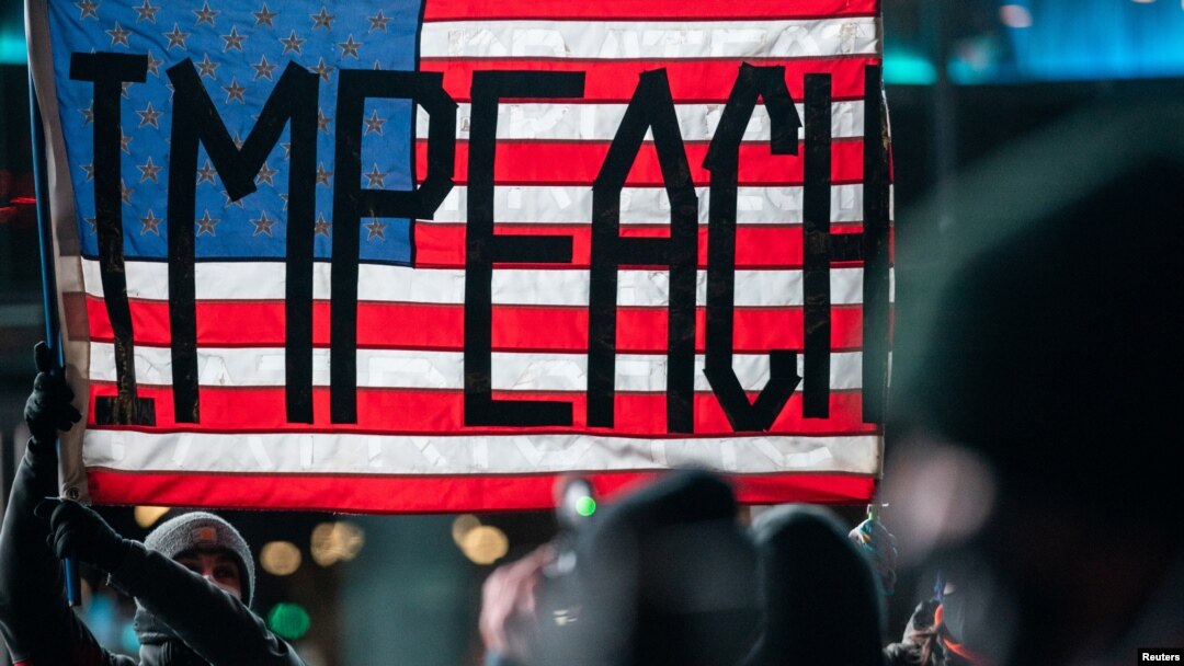Người biểu tình mang khẩu trang giương cờ đòi luận tội truất phế TT Trump tại Trung tâm Barclays ở New York ngày 7/1/2021, 1 ngày sau vụ bạo loạn tấn công điện Capitol. REUTERS/Jeenah Moon