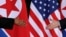 FILE - U.S. President Donald Trump and North Korea's leader Kim Jong Un reach to shake hands at the start of their summit at the Capella Hotel on the resort island of Sentosa, Singapore, June 12, 2018.