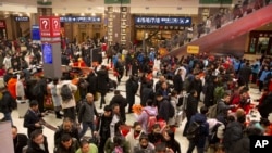 FILE - Travelers gather inside of the Beijing Railway Station in Beijing, Jan. 17, 2020. 