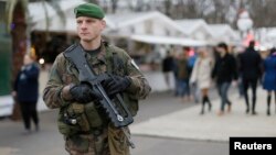 A French soldier patrols the Christmas market along Champs Elysees in Paris as part of the "Vigipirate" security plan, Dec. 23, 2014.