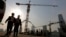 FILE - Workers walk out from a construction site at the Central Business District of Beijing, China, Jan. 20, 2015.
