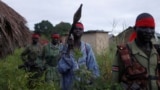 FILE - Sudan People's Liberation Army (SPLA-IO) rebels walk during an assault on government Sudan People's Liberation Army (SPLA) soldiers in the town of Kaya, South Sudan, Aug. 26, 2017.