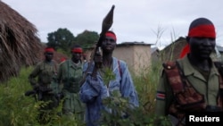 FILE - Sudan People's Liberation Army (SPLA-IO) rebels walk during an assault on government Sudan People's Liberation Army (SPLA) soldiers in the town of Kaya, South Sudan, Aug. 26, 2017.