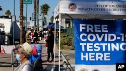 People wait in line to be tested for COVID-19 at a testing site in the North Hollywood section of Los Angeles on Saturday, Dec. 5, 2020. With coronavirus cases surging at a record pace, California Gov. Gavin Newsom announced a new stay-at-home order…