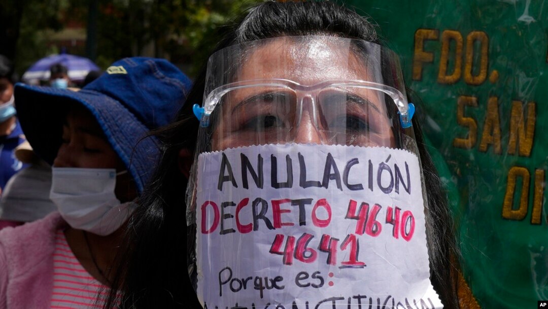 Una mujer usa un protector facial con el mensaje en español: "Anulación de los decretos 4640 y 4641, porque es inconstitucional" durante una protesta contra los decretos gubernamentales que requieren prueba de vacunación en La Paz, el lunes 10 de enero.