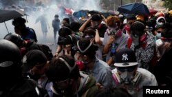 Los manifestantes intentan escapar del gas lacrimógeno mientras abandonan el campus de la Universidad Politécnica de Hong Kong, en medio de los enfrentamientos con la policía en Hong Kong, el 18 de noviembre de 2019.