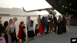 Afghans prepare to to be evacuated aboard a Qatari transport plane, at Hamid Karzai International Airport in Kabul, Afghanistan, August, 18, 2021. (Qatar Government Communications Office via AP)