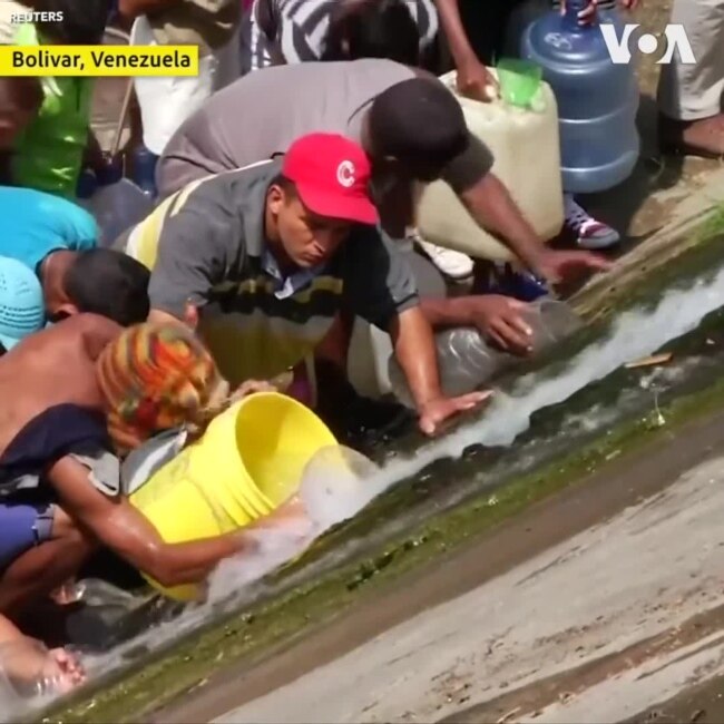 Mất điện tiếp diễn, dân Venezuela chen chúc hứng nước thải