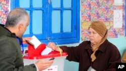 FILE - A Tunisian votes in the second round of the legislative elections in Tunis, Sunday, Jan. 29, 2023. 