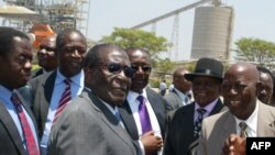 Le président Robert Mugabe du Zimbabwe, au centre, salue des chefs locaux à la mine Zimplats, près de Harare, le 13 Octobre 2011. 