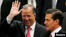FILE - Jose Antonio Meade waves next to President Enrique Pena Nieto during an event where Pena Nieto announced the resignation of Antonio Meade as finance minister, in Mexico City, Nov. 27, 2017. 