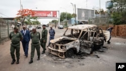 Border officials inspect a burnt-out Mozambican border patrol vehicle at the border crossing in Lebombo, South Africa, Nov. 7, 2024.