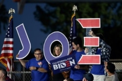 FILE - Supporters hold a sign before a campaign rally for Democratic presidential candidate former Vice President Joe Biden, in Los Angeles, California, March 3, 2020.