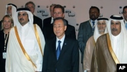 ທ່ານ Ban Ki-Moon ຢືນຢູ່ທາງຂ້າງຈາກອົງມົງກຸດ Sheikh Tamim bin Hamad al-Thani ແຫ່ງ Qatar .ໃນການຖ່າຍຮູບຮ່ວມກັນຂອງບັນດາລັດຖະມົນຕີຕ່າງປະເທດທີ່ມາຮ່ວມກອງປະຊຸມ ທີ່ນະຄອນຫລວງ Doha ວັນທີ 13 ເມສາ, 2011