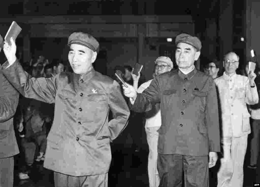 1967年5月，在北京的一次会议上，5位高官列队，举着毛语录。林彪（1907-1971）在前，周恩来（1898-1976）随后，当时的中共第四号人物、中央文革小组组长陈伯达第三，中共第五号人物、中央文革小组顾问康生第四，毛泽东夫人、中央文革小组副组长江青第五，这显示当时她是中共第六号人物，尽管她连中央委员都不是。后来陈伯达被毛泽东打倒，林彪出逃后也被打倒。江青在毛死后被抓，康生在1980年被开除出党，骨灰被&ldquo;开除&rdquo;出八宝山。这五个人除了周恩来，都在1980年被列為林彪、江青反革命集团主犯。