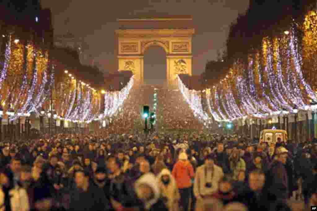 Thousands of revellers celebrate the New Year on the Champs Elysees avenue in Paris, France, 01 Jan 2011. (Reuters Image)