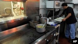 FILE - Carlos Chavez, works in the kitchen of his restaurant by himself on "A Day Without Immigrants," July 1, 2011, in Atlanta. Chavez gave his workers the day off, however with other restaurant owners open he decided he couldn't afford to remain closed.