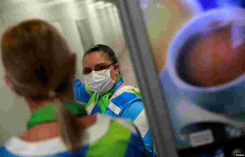 Una mujer usa una máscara como medida de precaución debido al coronavirus mientras trabaja en el aeropuerto Salgado Filho en Porto Alegre, Brasil. 