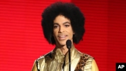 FILE - Prince presents the award for favorite album - soul/R&B at the American Music Awards in Los Angeles, Nov. 22, 2015. 