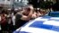 A striking municipal police officer reacts as he leans on a car with a Greek flag during a protest, against new austerity cuts that will affect thousands of public sector workers, in Athens. The government has committed to firing 15,000 people by the end of 2014 and transferring another 12,500 to new positions this year.