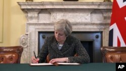 La primera ministra británica, Theresa May, firma la carta oficial al presidente del Consejo Europeo, Donald Tusk, el 28 de marzo de 2017, invocando el artículo 50 de la Unión Europea, el comienzo formal de la salida del bloque.
