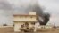 Smoke billows from a building after a Taliban attack in Gereshk district of Helmand province, Afghanistan on March 9, 2016. 