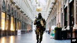 FILE - In this Nov. 26, 2015 file photo, a Belgian Army soldier walks through the Galleries Royal Saint-Hubert in the center of Brussels. 