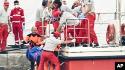 ARCHIVO - Buzos de bomberos italianos llevan a tierra en una bolsa de plástico el cuerpo de una de las víctimas de un naufragio, en Porticello, Sicilia, sur de Italia, el jueves 22 de agosto de 2024. (Foto AP/Salvatore Cavalli)