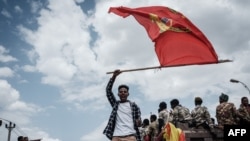 A man waves a Tigray flag as Soldiers of Tigray Defense Force return in Mekele, the capital of Tigray region, Ethiopia, on June 29, 2021. 