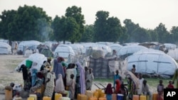 FILE - People displaced by Islamist extremists queue for water at the Muna camp, in Maiduguri, Nigeria, Aug. 30, 2016.