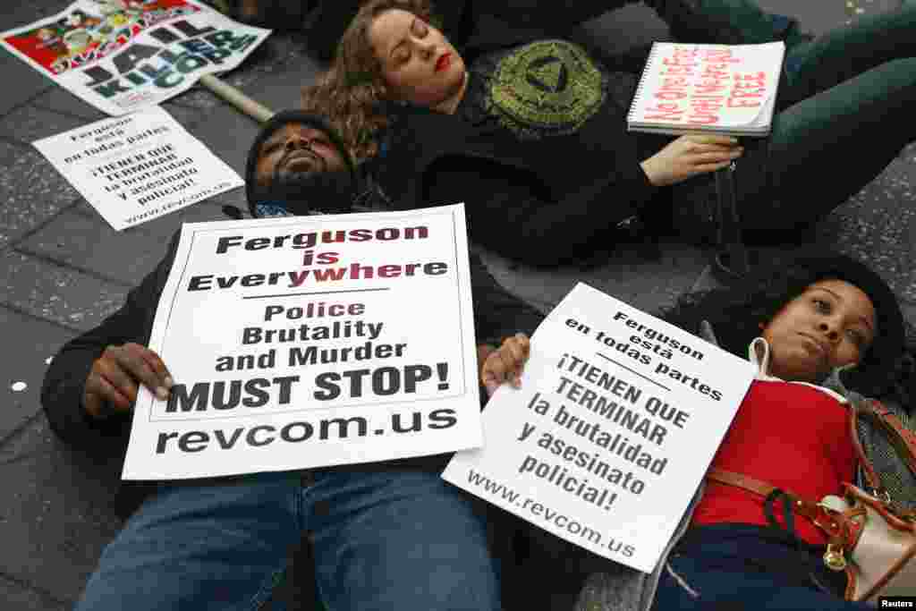 Pessoas deitam-se na estrada, bloqueando o trânsito na Times Square em Nova Iorque, em forma de protesto depois do Grande Júri não ter indiciado criminalmente um polícia por ter morto um jovem em Ferguson, Missouri. EUA