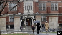 FILE - People walk near the campus center at Princeton University in Princeton, N.J., Dec. 9, 2013. 