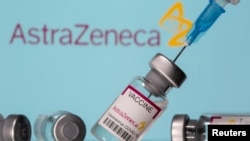 FILE PHOTO: Vials labelled "Astra Zeneca COVID-19 Coronavirus Vaccine" and a syringe are seen in front of a displayed AstraZeneca logo, in this illustration photo taken March 14, 2021.